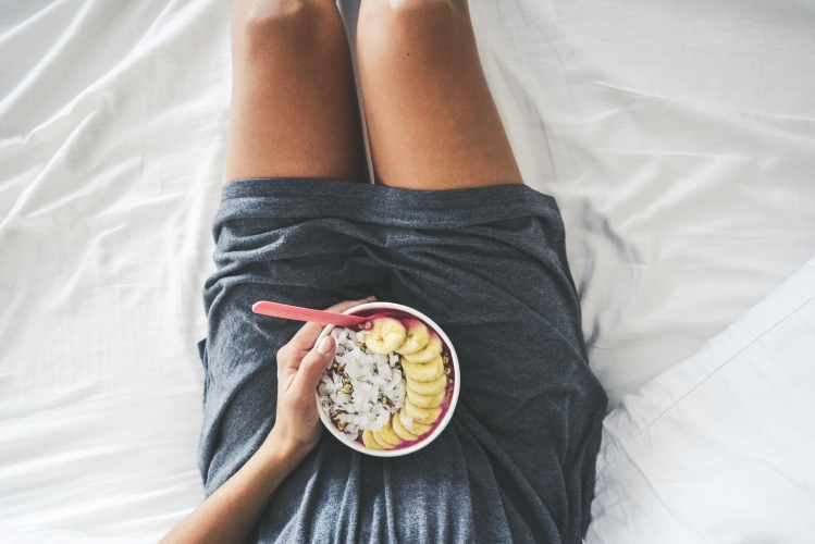 woman holding breakfast pitaya bowl in bed